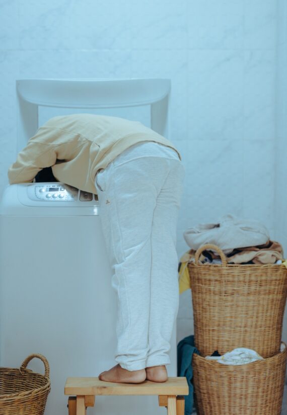 woman leaning into a washer cleaning a sturdibag pet carrier