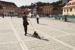 woman walking a cat through a town square